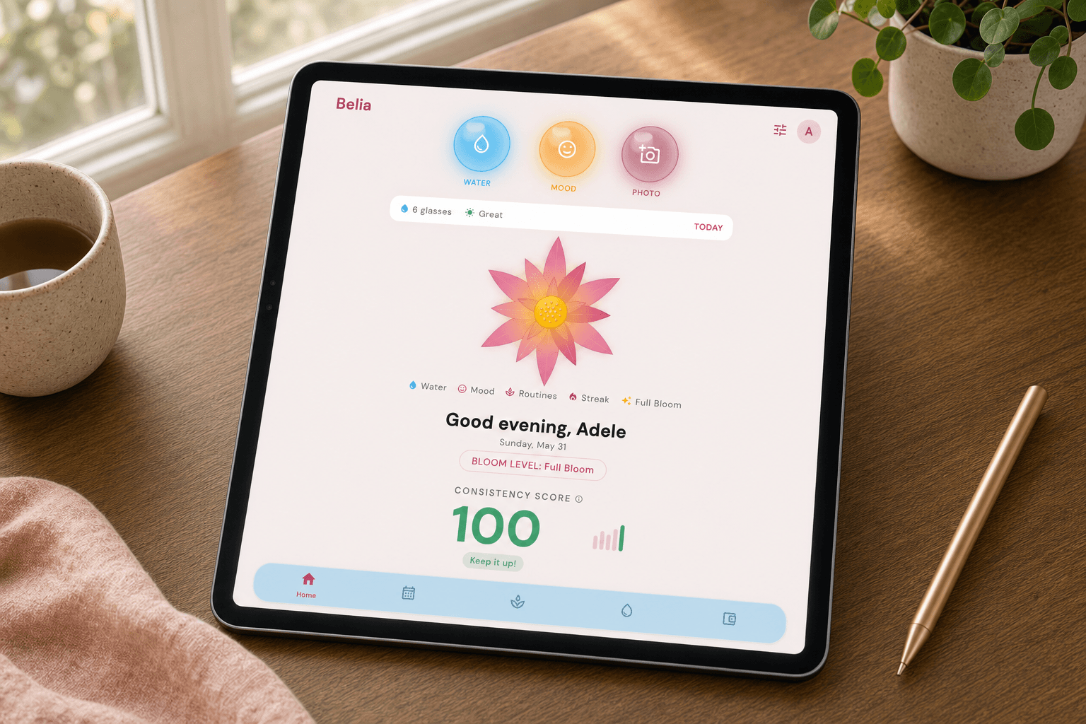 Belia Full Bloom wellness dashboard displayed on an iPad beside a cup and stylus